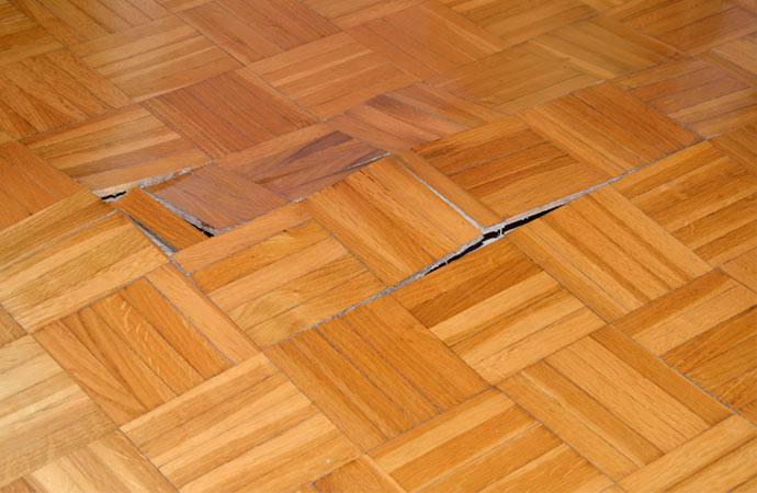 Wooden floor showing water damage from leaks.